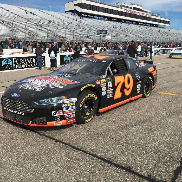 Black and orange wrapped race car on track